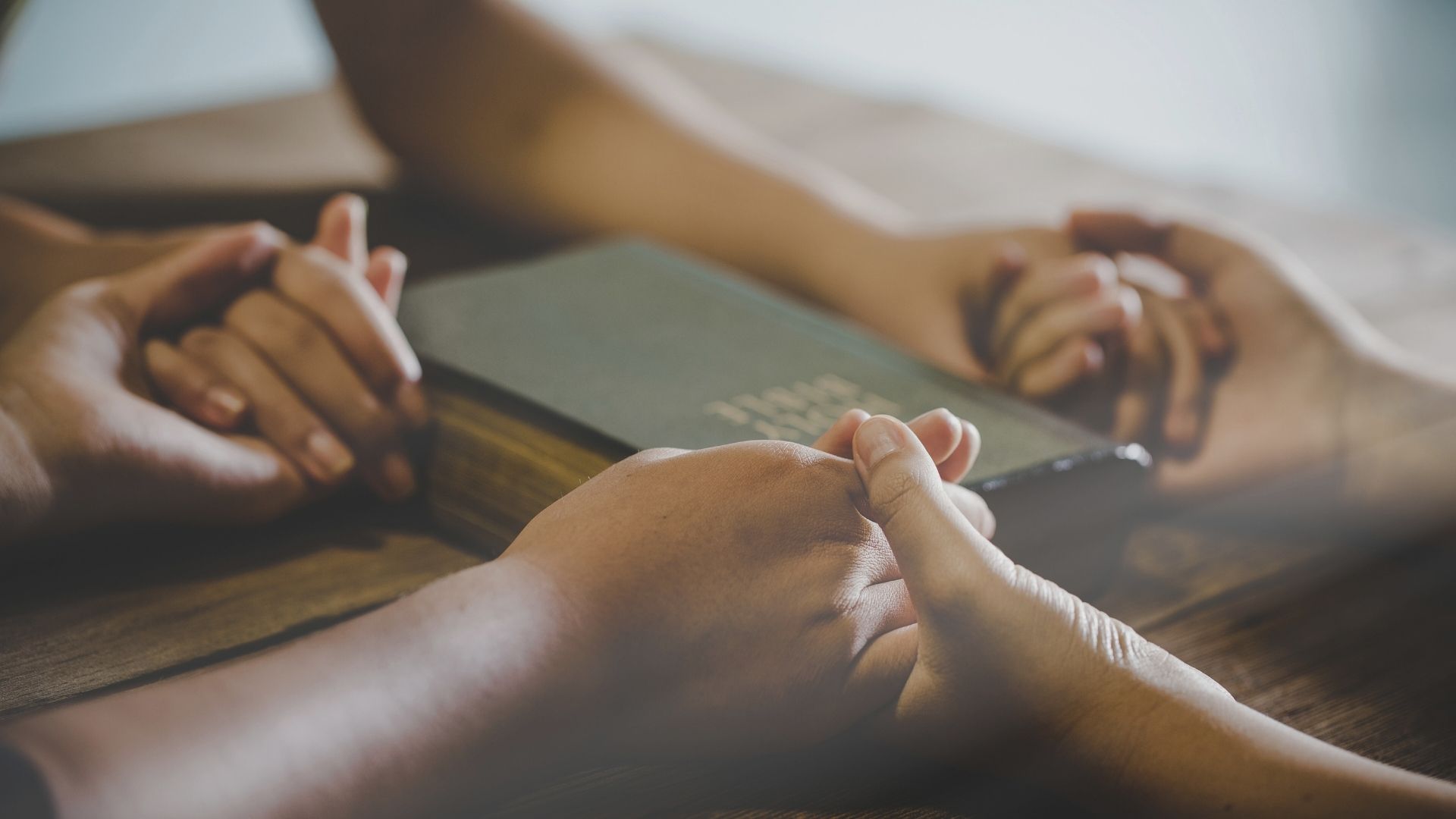 Group of people praying over the bible to a prayer story