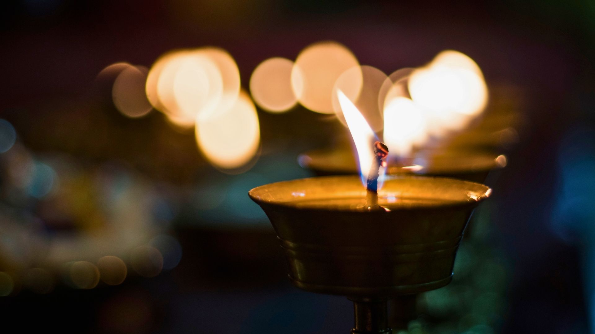 spiritual growth in michigan line of lit candles for a held vigil in a dark setting