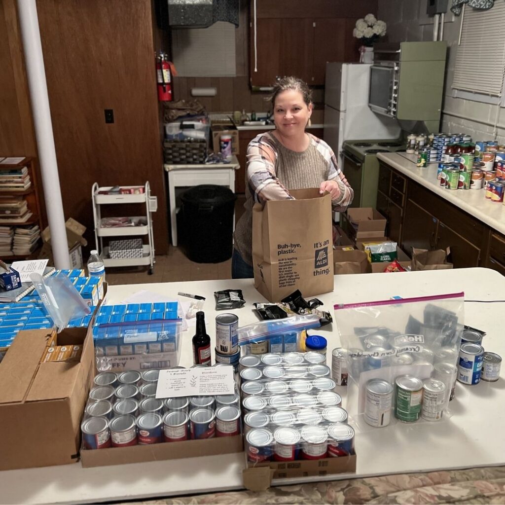 woman standing at a table packaging food