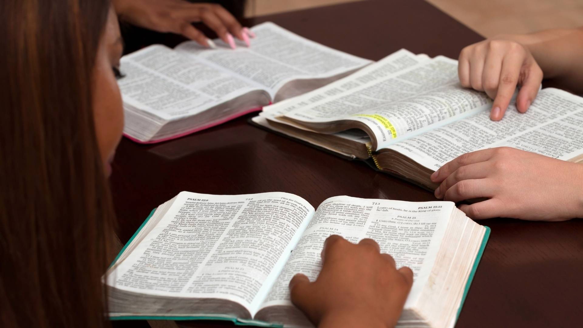 group of students reading and learning the bible on a table