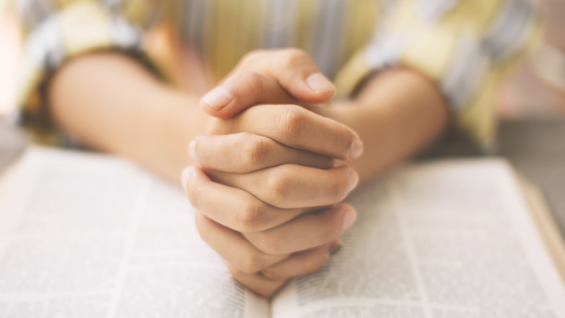 woman clasping her hands and praying